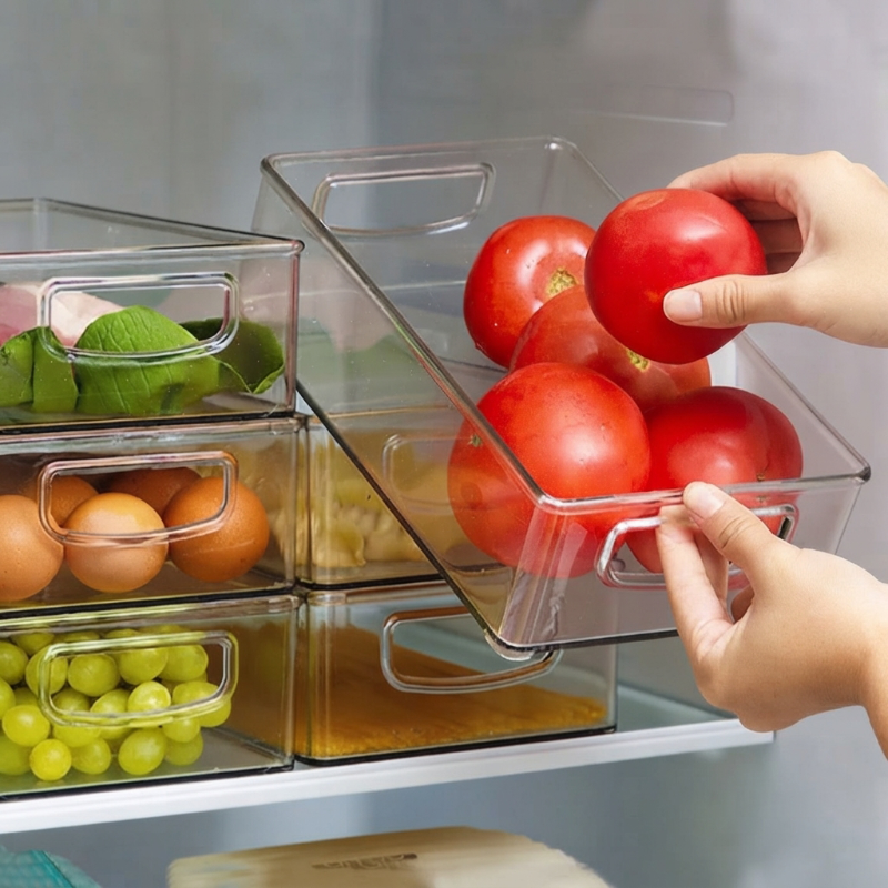 une main tire l'Organisateur frigo rempli de tomates