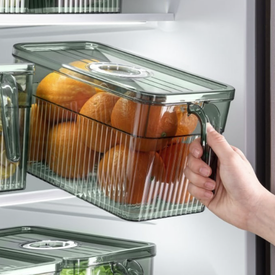 Une main prend la poignée du rangement frigo